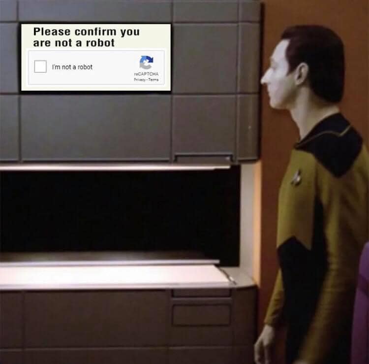 This meme is a humorous take on the "I'm not a robot" checkbox that appears on many websites to verify that a user is human. The image shows a character from Star Trek: The Next Generation, Captain Jean-Luc Picard, standing in front of a computer terminal with a "I'm not a robot" checkbox on the screen. The caption "I'm not a robot" is likely a sarcastic response to the idea that a Star Trek captain would need to verify his humanity.
